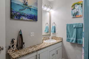 Bathroom with a textured wall and vanity