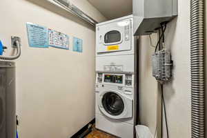 Laundry area with stacked washing machine and dryer and water heater