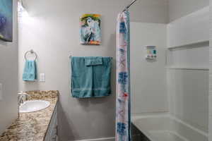 Bathroom with vanity, a textured wall, and shower / tub combo