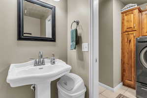 Half bathroom featuring washer / dryer and light tile patterned floors