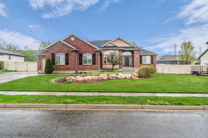 Single story home with brick siding, a gate, and driveway