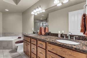 Bathroom featuring double vanity, a stall shower, a bath, light tile patterned flooring, and recessed lighting