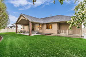 Rear view of house featuring a patio area, roof with shingles, and stucco siding