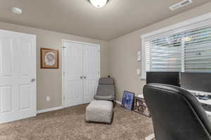 Carpeted office space with baseboards and a textured ceiling