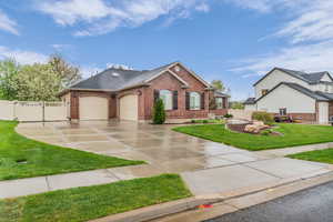 View of front facade featuring an attached garage, concrete driveway, brick siding, and a shingled roof