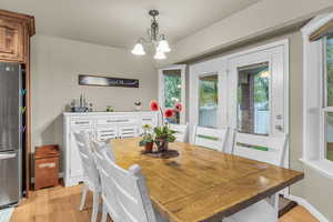 Dining space with light wood-style floors and hanging lights