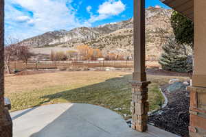 Fenced backyard with a mountain view, a patio area, and a view of countryside