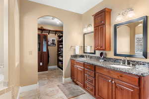 Bathroom with double vanity and a walk in closet