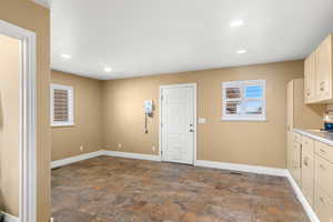 Kitchen with dark stone finish flooring, light countertops, and recessed lighting