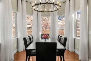 Dining area with suspended lighting and wood finished floors