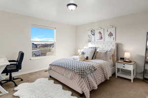 Bedroom with an office area and light colored carpet