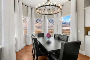 Dining area with wood finished floors, hanging lights, and a mountain view