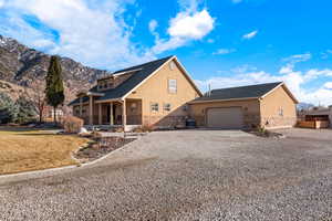 View of front of house featuring stone siding, stucco siding, concrete driveway, and a porch
