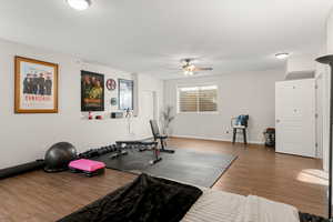 Exercise area with wood finished floors and a ceiling fan