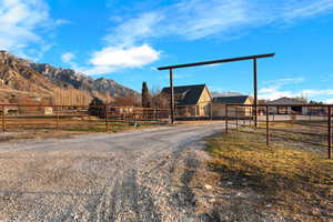 View of dirt / gravel road featuring a mountain view and a gated entry