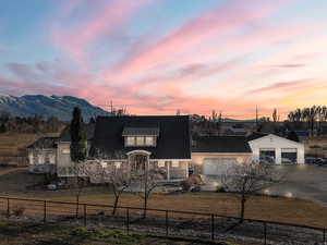 View of front of house featuring stucco siding, driveway, a detached garage, and a fenced front yard