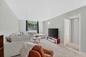 Living room featuring light carpet and floor to ceiling windows