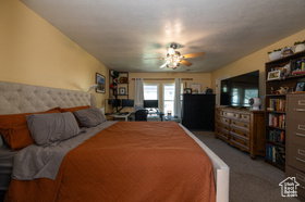 Carpeted bedroom featuring ceiling fan