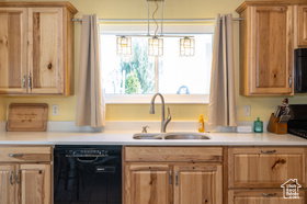 Kitchen with black dishwasher, light countertops, stainless steel range oven, and pendant lighting