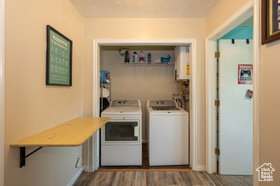 Laundry area featuring dark wood-style flooring, washer and clothes dryer, and water heater