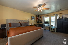 Carpeted bedroom featuring a ceiling fan