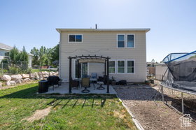 Back of property featuring a trampoline, a patio area, and a pergola