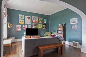Living area with arched walkways and wood finished floors