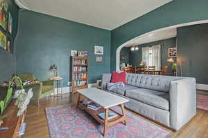 Living room with arched walkways and wood finished floors