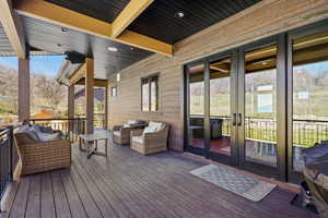 Wooden terrace featuring an outdoor living space and french doors