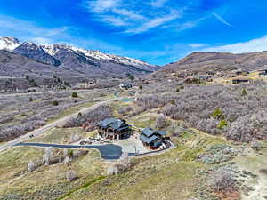 Aerial view of property and surrounding area featuring a mountainous background
