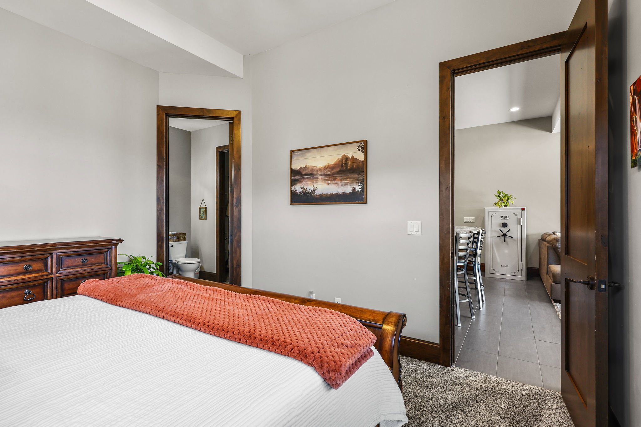 Bedroom featuring connected bathroom, light carpet, and light tile patterned flooring