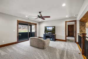 Living room featuring ceiling fan, light carpet, and recessed lighting