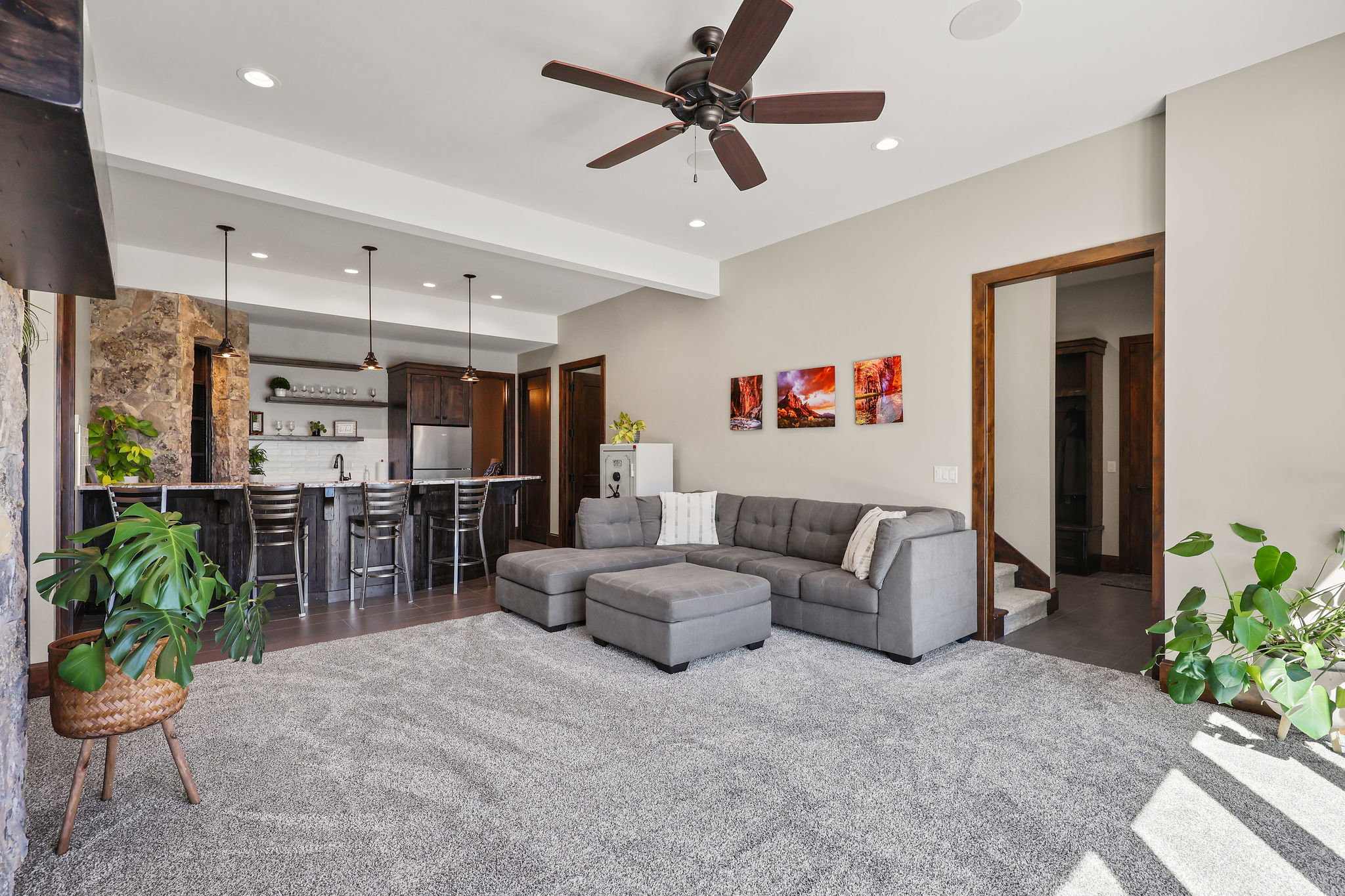 Living room with beam ceiling, bar with sink, recessed lighting, and a ceiling fan