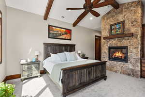 Carpeted bedroom with vaulted ceiling with beams, a fireplace, ceiling fan, and recessed lighting