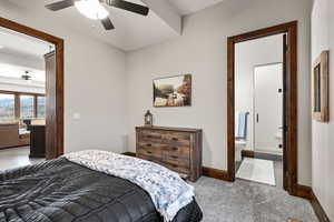Bedroom featuring light carpet, connected bathroom, and a ceiling fan