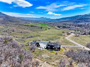 Aerial view of property and surrounding area with a mountainous background
