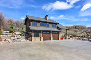 View of front of property with an attached garage, roof with shingles, driveway, and a chimney