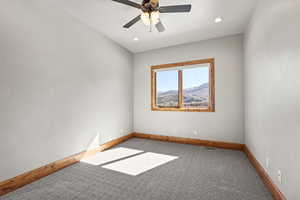 Spare room featuring light colored carpet, ceiling fan, recessed lighting, and a mountain view