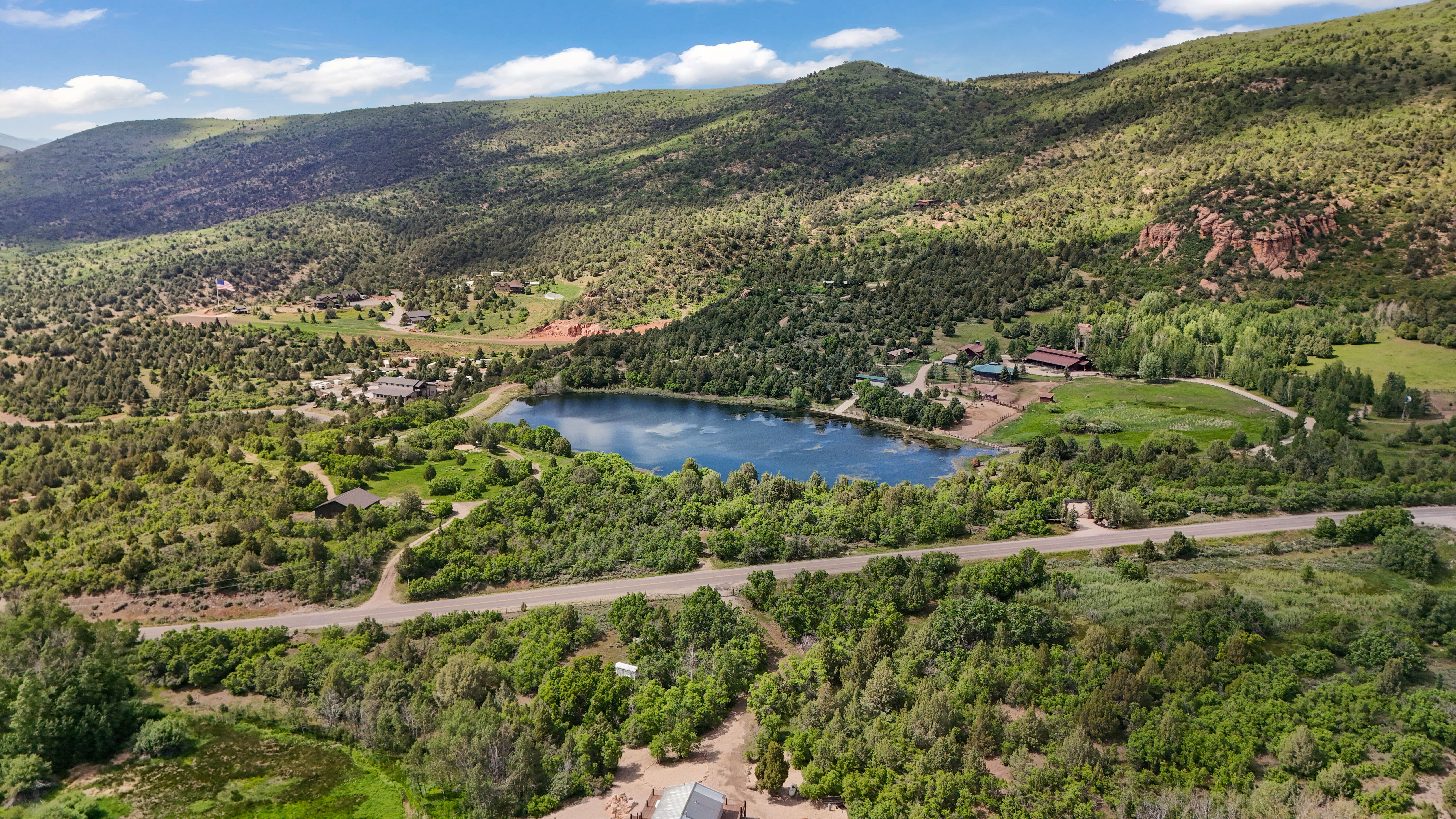 Drone / aerial view of a water and mountain view and a heavily wooded area