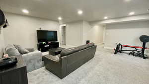 Living area with light colored carpet and recessed lighting