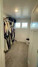 Walk in closet featuring dark colored carpet