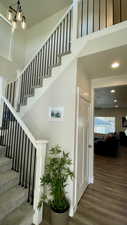 Stairs with wood finished floors and a chandelier