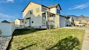 View of side of home with concrete driveway, a mountain view, board and batten siding, a residential view, and a garage