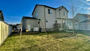 Back of house with a fenced backyard and stucco siding