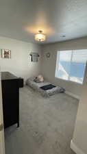Bedroom featuring a textured ceiling and light carpet