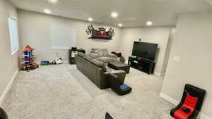 Living room with light colored carpet and recessed lighting