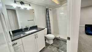 Full bathroom featuring vanity, a shower stall, and a textured ceiling