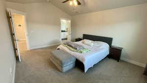 Carpeted bedroom featuring vaulted ceiling, ceiling fan, and ensuite bathroom