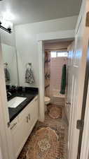 Bathroom featuring vanity, shower / bath combo, and a textured ceiling