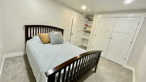 Bedroom with light colored carpet and a closet